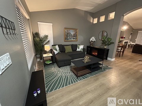 A living room with a black couch and a fireplace.