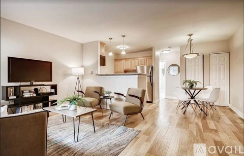A living room with a brown sofa, a white coffee table, and a dining table with chairs.