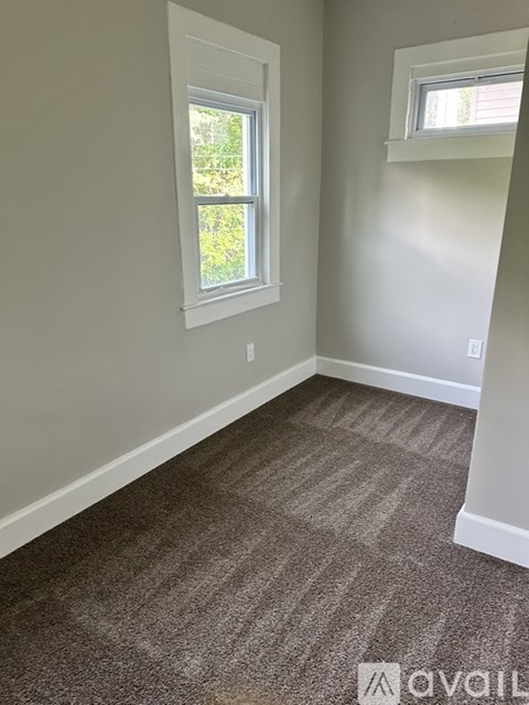 A room with a carpeted floor and a window.