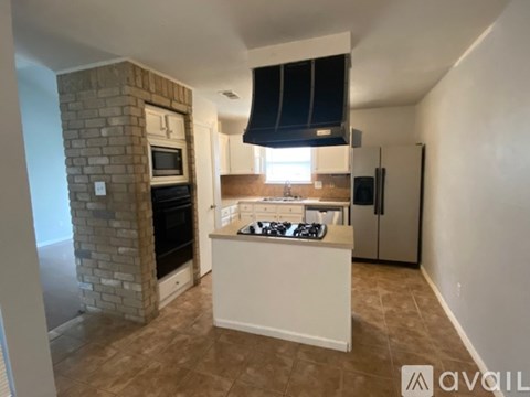 A kitchen with a brick oven and a white island.