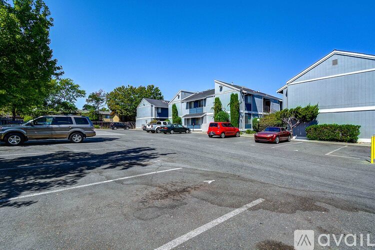 A parking lot with cars and buildings in the background.