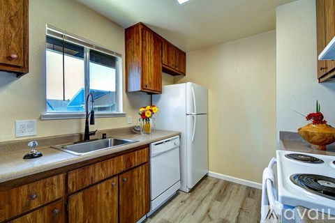 A kitchen with wooden cabinets and a white refrigerator.
