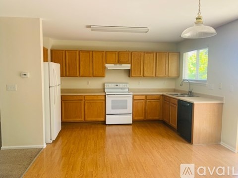 A kitchen with wooden cabinets and white appliances.