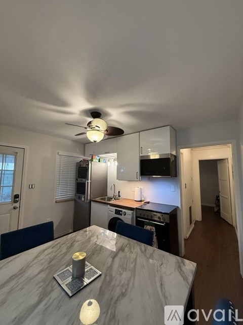 A kitchen with a marble table and a ceiling fan.