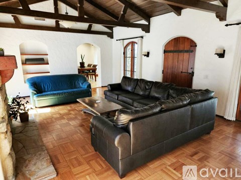 A living room with a black leather couch and a blue sofa.