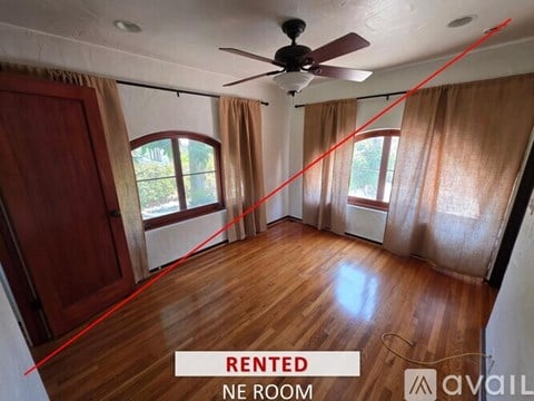 A spacious room with a stone fireplace and a wooden ceiling.
