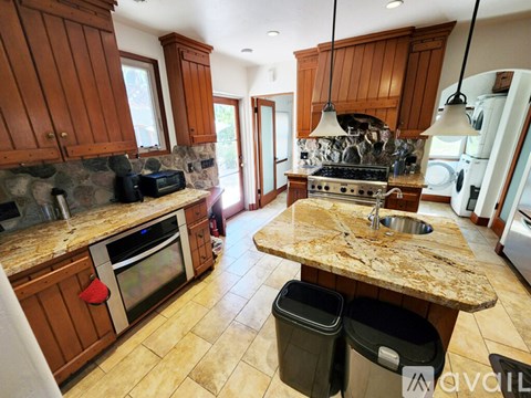 A kitchen with wooden cabinets and a granite countertop.