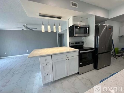 A kitchen with a marble countertop and stainless steel appliances.
