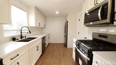A kitchen with white cabinets and a black stove top oven.