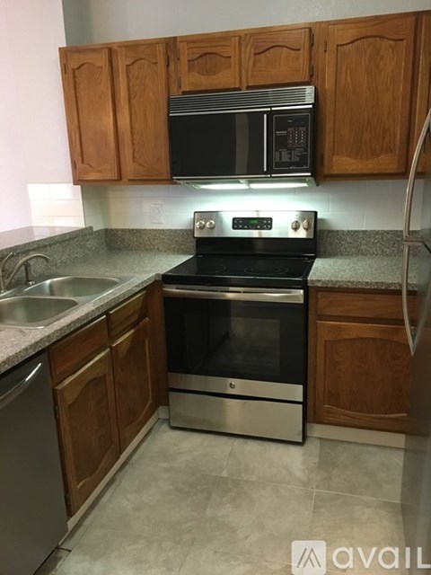 A kitchen with a black oven and wooden cabinets.