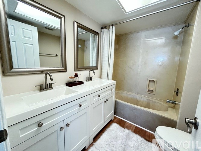 A bathroom with a white vanity and a glass shower stall.