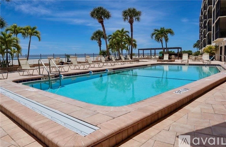A large outdoor swimming pool surrounded by palm trees.