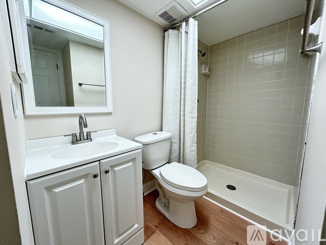 A white bathroom with a toilet, sink, and bathtub.