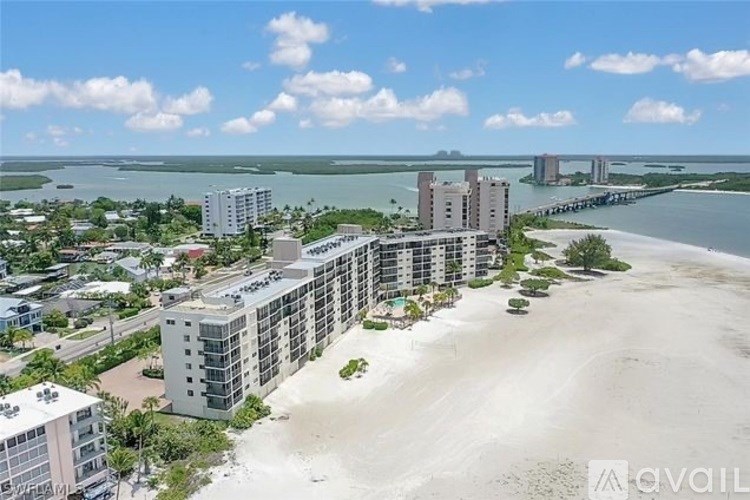 A beachfront resort with a bridge in the background.