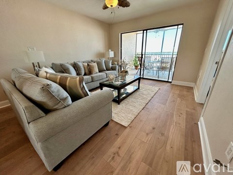 A living room with a grey couch and a glass coffee table.