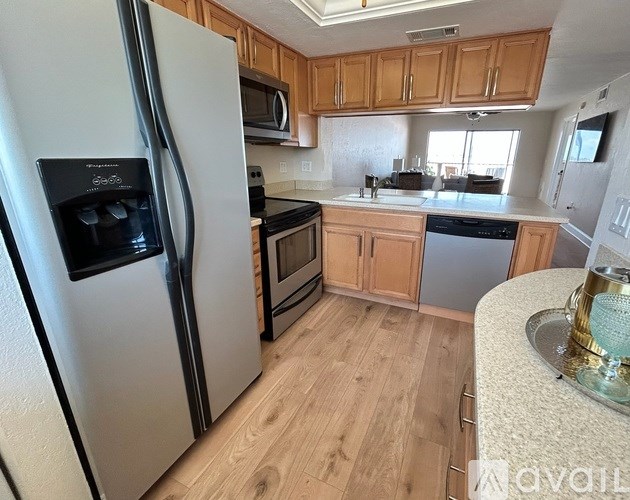 A kitchen with a white fridge and wooden cabinets.
