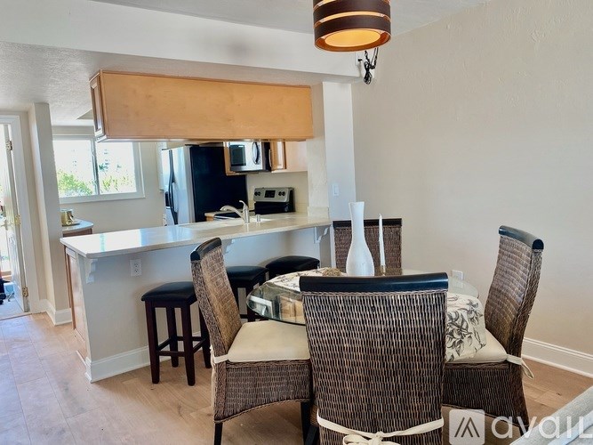 A kitchen with a bar and chairs.