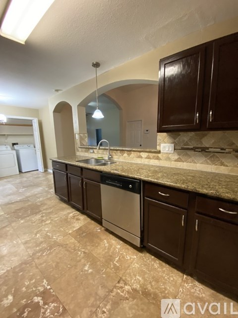 A kitchen with brown cabinets and a tiled floor.