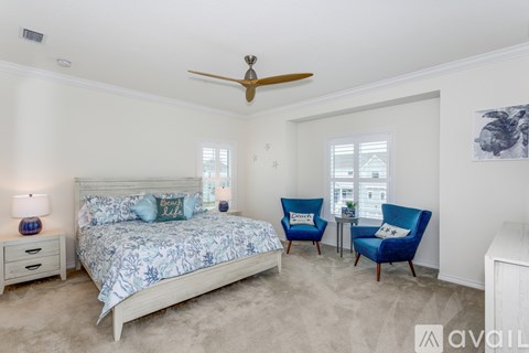 A bedroom with a large bed and a blue chair.