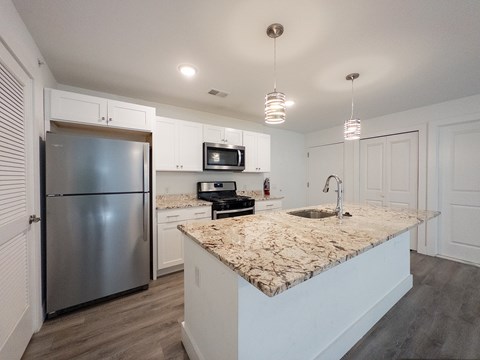 A kitchen with white cabinets and a white counter top.