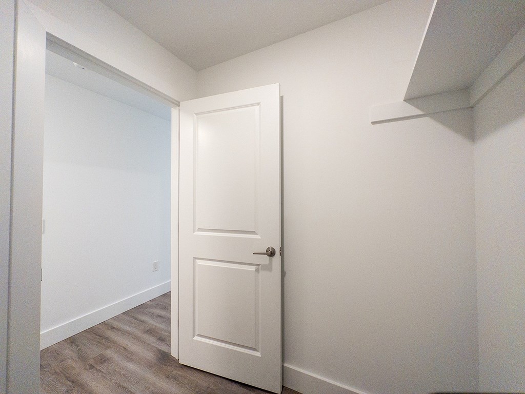 A white door is in a room with white walls.
