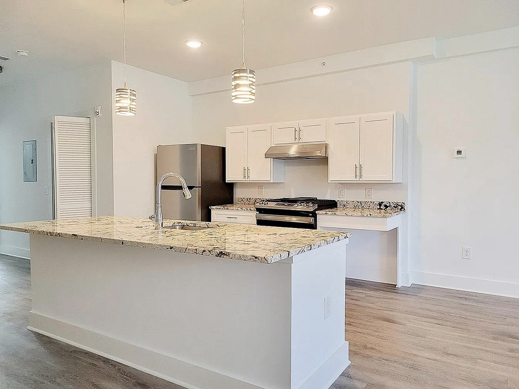 A kitchen with a granite countertop and stainless steel appliances.