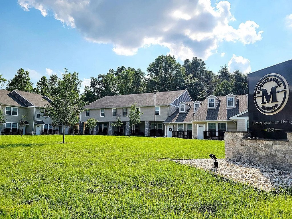A sign with the letter M on it is in front of a building.