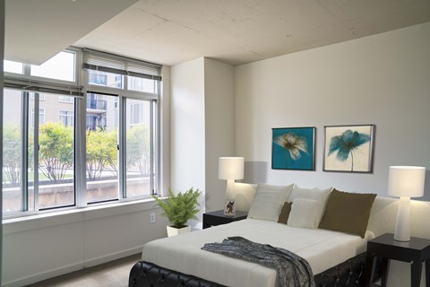 A bedroom with a large bed and two lamps.