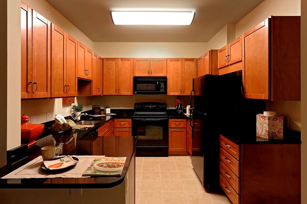 A kitchen with wooden cabinets and black appliances.