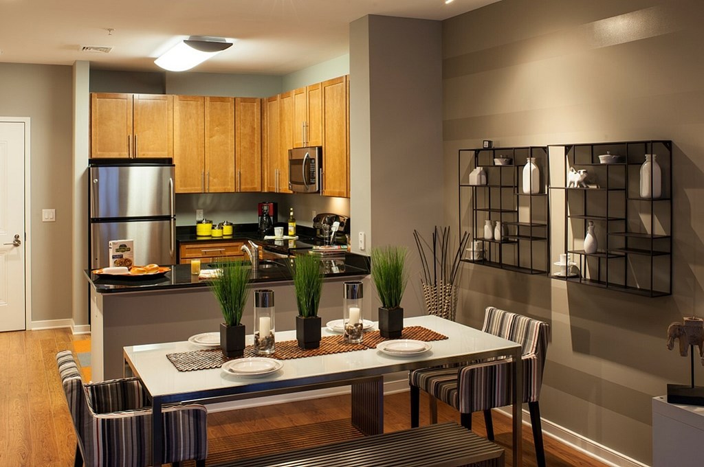A modern kitchen with a dining table set for two.