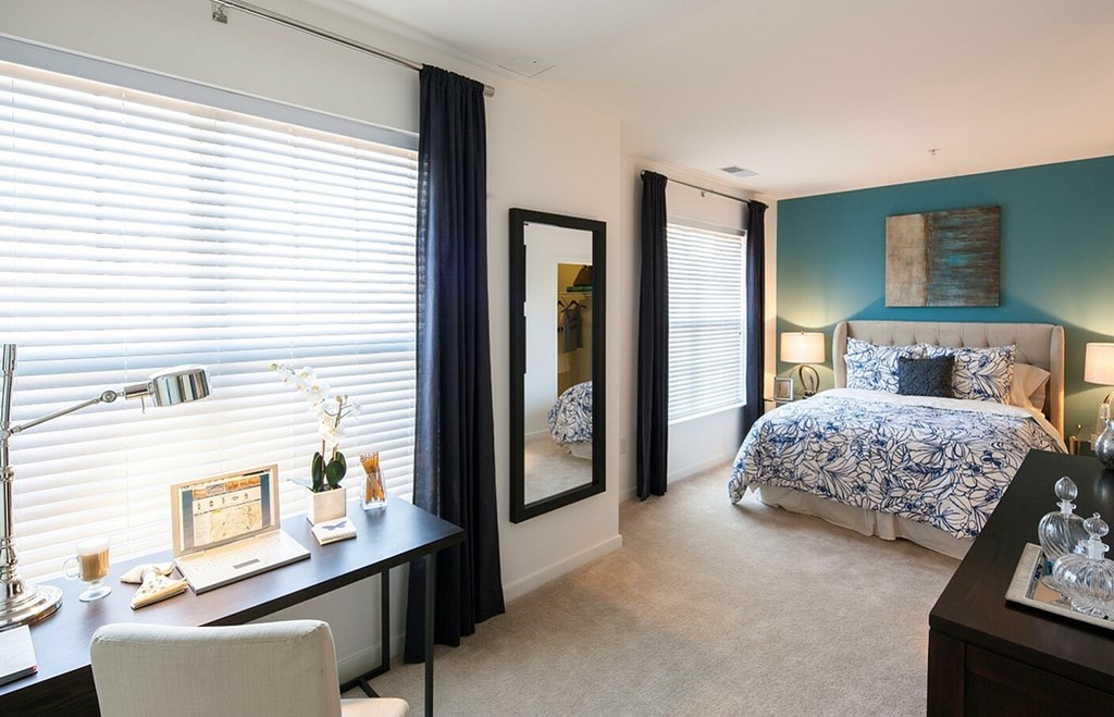 A bedroom with a bed, desk, and chair.