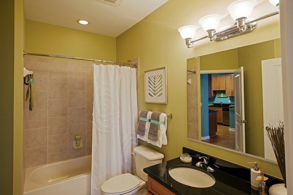 A bathroom with a green wall and a white toilet.