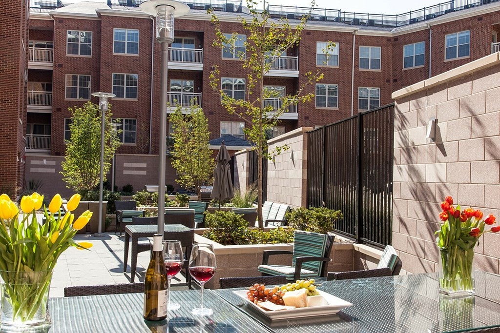 A table with a plate of food, a bottle of wine, and a glass of wine on it.