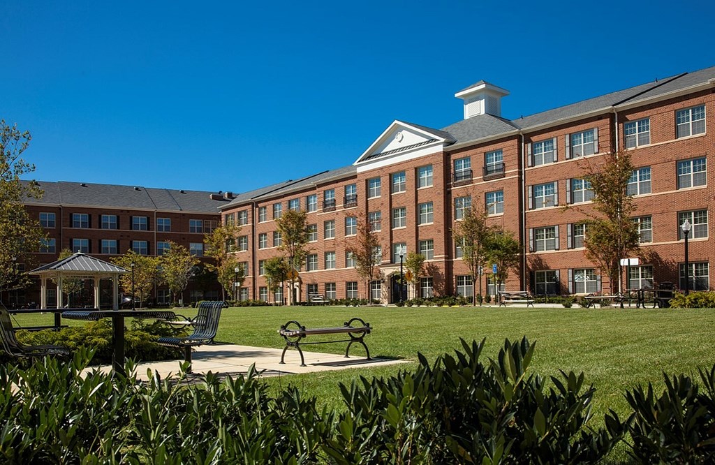 A large red brick building with a gazebo in front of it.