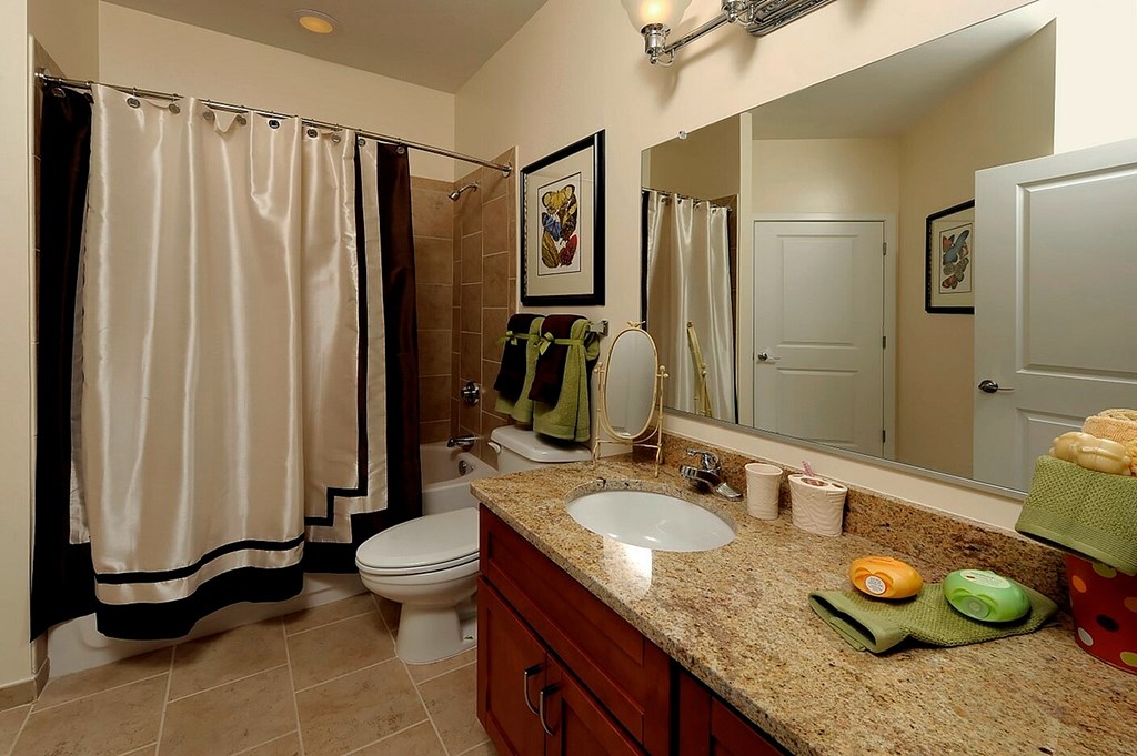 A bathroom with a toilet, sink, and shower.