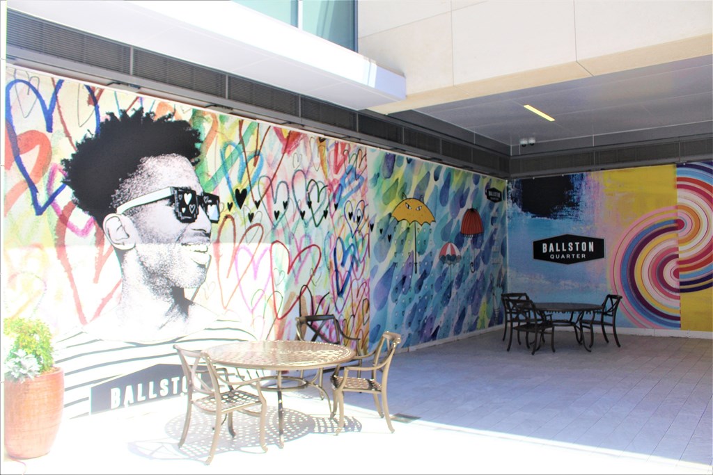 A graffiti wall with a man wearing sunglasses and a mohawk hairstyle.