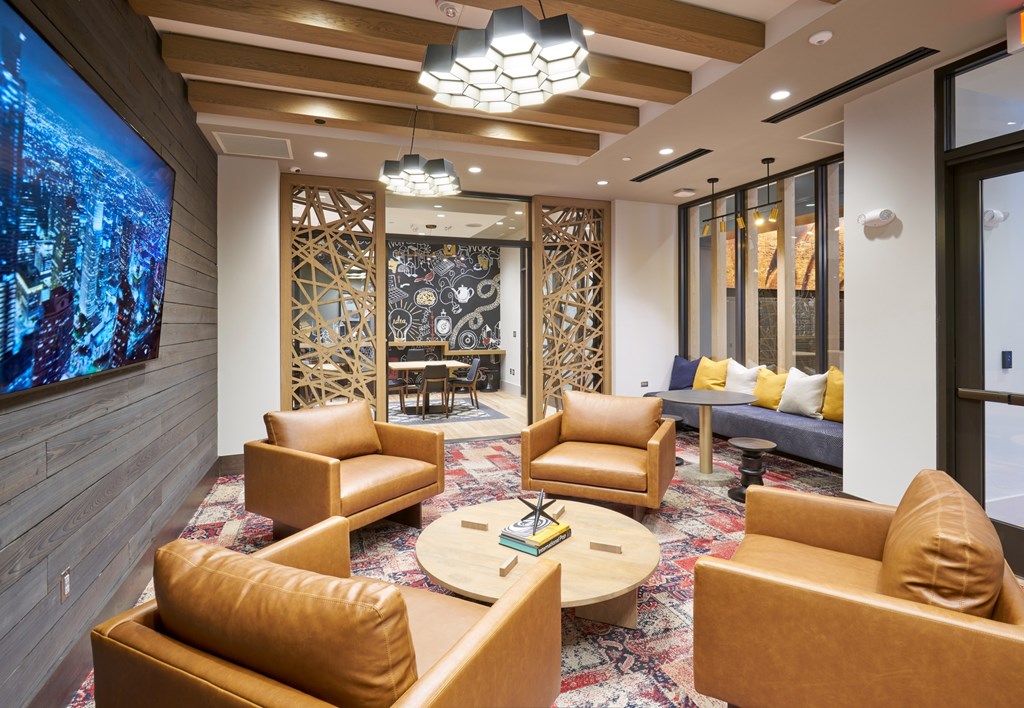 A modern living room with a large screen on the wall.