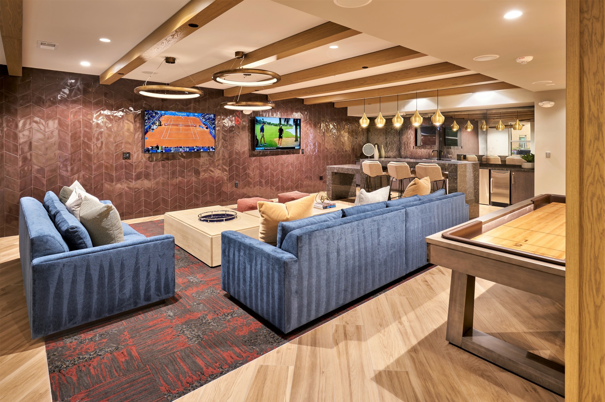 A modern living room with blue couches and a wooden coffee table.
