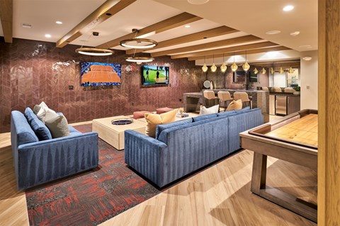 A modern living room with blue couches and a wooden coffee table.