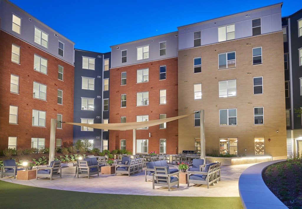 A modern apartment complex with a courtyard and seating area.