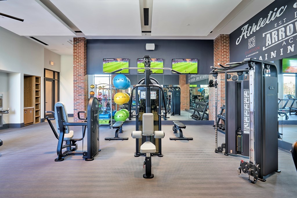 A gym with a variety of equipment including a rowing machine.