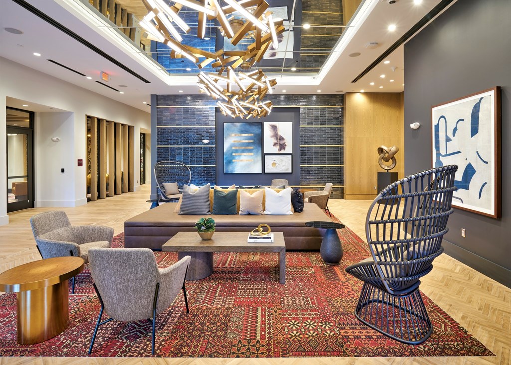 A modern living room with a large rug and a wooden chandelier.