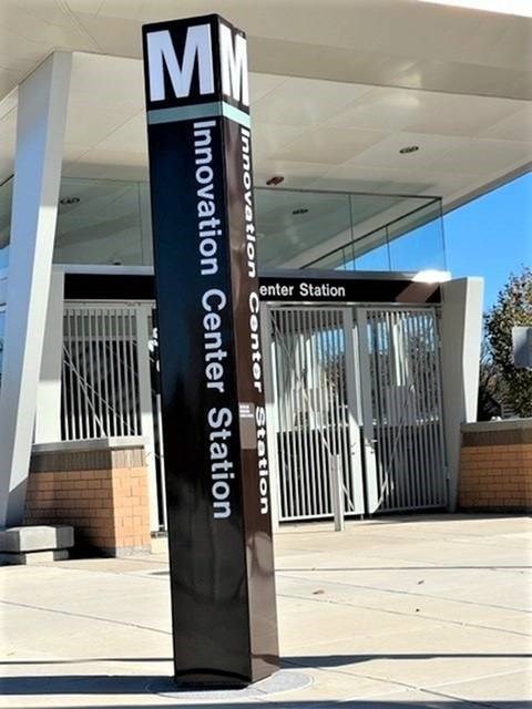 A sign for the Innovation Center Station stands in front of a building.