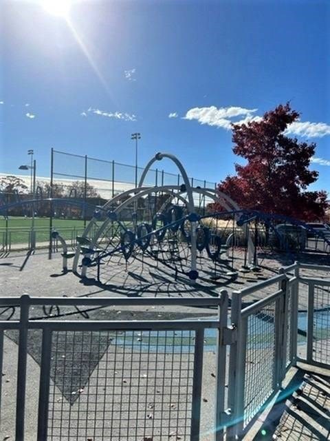 A playground with a swing set and a basketball court.