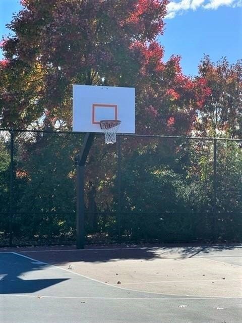 A basketball hoop is mounted on a pole in a park.
