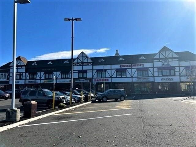 A parking lot in front of a building with cars parked.