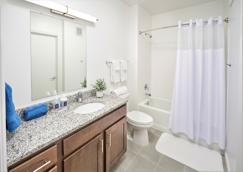 A bathroom with a white shower curtain and a white toilet.