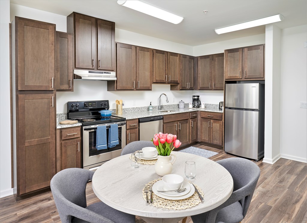 A modern kitchen with a table set for two.