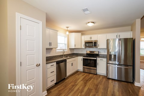 A kitchen with a stainless steel refrigerator, oven, and microwave.