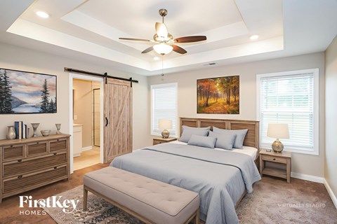 A bedroom with a bed, nightstands, and a ceiling fan.